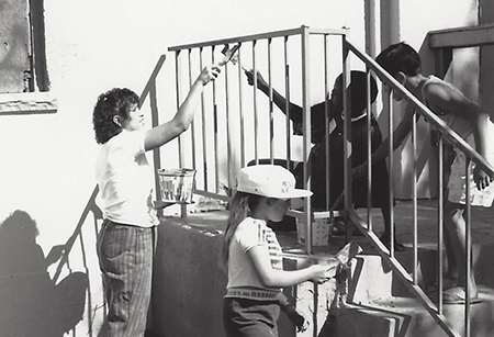 children and adults working together painting steps.