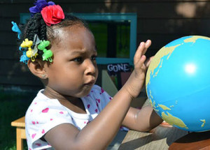 young pupil looks at a globe with curiosity 